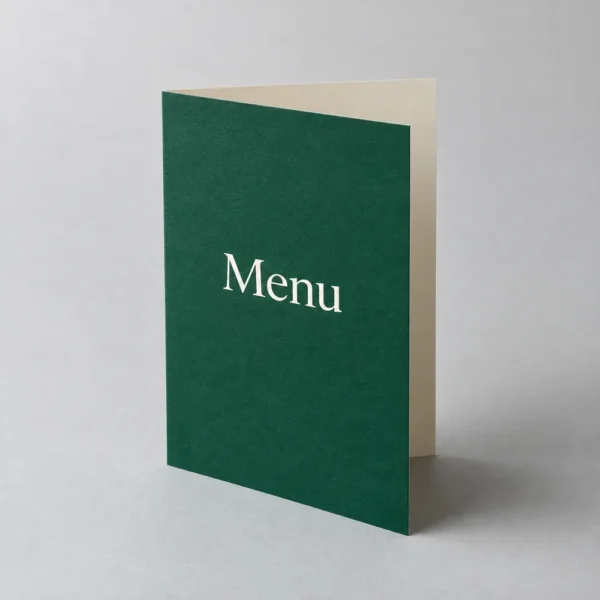 Folded forest green restaurant menu standing on a studio surface